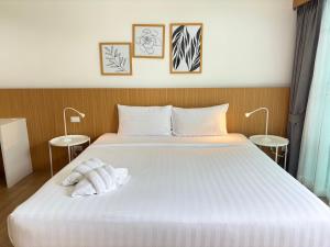 um quarto com uma grande cama branca com duas mesas em Xen Pool Access em Ban Klang