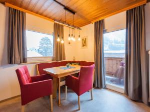 a dining room with a table and red chairs at Modern Apartment in Kitzbuhel near Ski Area in Kitzbühel