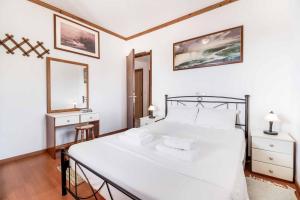 a bedroom with a large white bed and a mirror at Villa Mulberry in Stoupa +27 photos