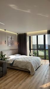 a bedroom with a large bed and a large window at luxury Apartmens na Duhnovicha , напроти Аквапарка "Карпатія" in Mukacheve