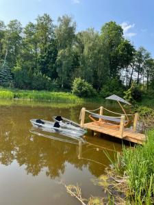 a boat is parked next to a wooden dock at Chatka Młynarza in Sochocin +7 photos