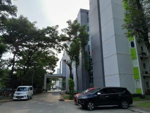 two cars parked in a parking lot next to a building at Smart Inn at Aeropolis Residence in Teko