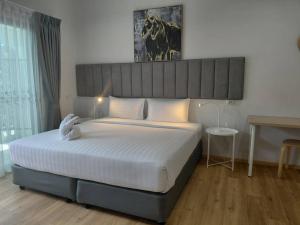 um quarto com uma cama grande e um bicho de peluche. em Xen Pool Access em Ban Klang