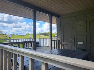 een veranda met een tafel en uitzicht op een veld bij Ritausmas Krasts 