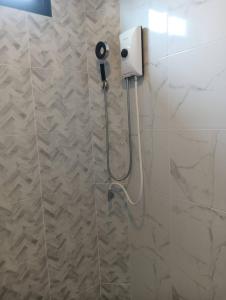 a shower in a bathroom with a blow dryer on the wall at Lemony Pool Villa - Hua Hin in Ban Thap Tai (1)