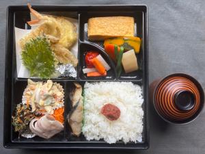 内海にあるサポートイン南知多のご飯とさまざまな種類の食べ物が載った黒いトレー