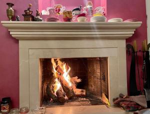 a fireplace with a white mantle with a fire in it at Fenix Villa in Noicattaro