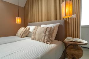 a bedroom with a bed with pillows and a table with a book at Wellness Lodges x De IJsvogel in Voorthuizen +96 photos