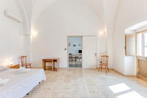 a room with white walls and a table and chairs at Casa Saulle - Costruzione Tipica in Felline
