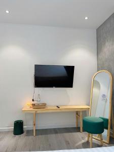 a room with a desk with a television on a wall at PuLin Homestay in Thôn Dương Xuân Hạ