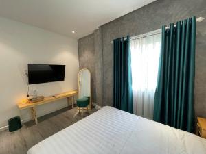 a bedroom with a bed and a desk and a television at PuLin Homestay in Thôn Dương Xuân Hạ
