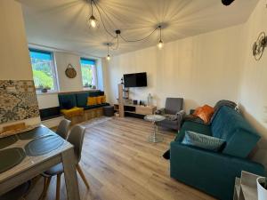 a living room with a blue couch and a tv at Przystanek Piechowice in Piechowice