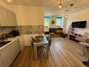 a kitchen and living room with a table and chairs at Przystanek Piechowice in Piechowice