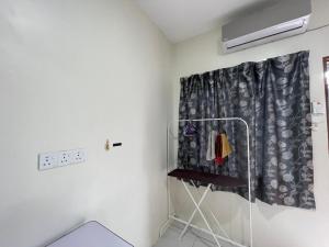 a room with a curtain and a clothes rack at Bilik 3 Katil Single Aircond Pekan in Pekan