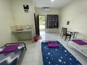 a room with two beds and a kitchen with a sink at Bilik 3 Katil Single Aircond Pekan in Pekan