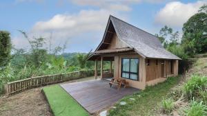 a small house with a wooden deck on a hill at Private Home in Jatiluwih