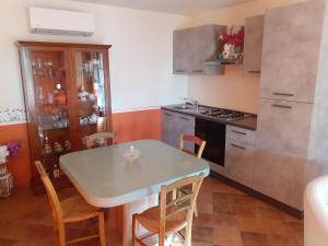 a kitchen with a table and chairs in a room at VILLETTA TRA GLI ULIVI in Citta' Sant'Angelo