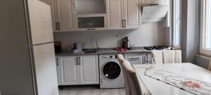 a kitchen with white cabinets and a washing machine at agırman in Çaykara