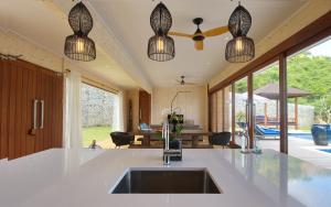 a kitchen with a sink and pendant lights at Selong Selo Resort and Residences in Selong Belanak