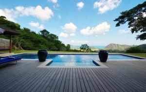 a swimming pool with a view of the ocean at Selong Selo Resort and Residences in Selong Belanak
