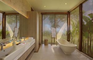 a bathroom with two sinks and a bath tub at Selong Selo Resort and Residences in Selong Belanak