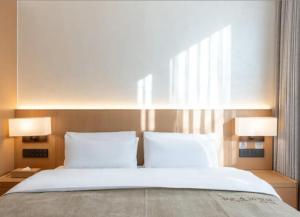 Ένα ή περισσότερα κρεβάτια σε δωμάτιο στο Qiana Hotel Houhai Gulou Street Subway Station Branch