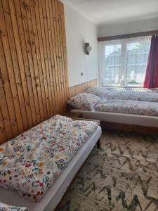 una habitación con dos camas y una ventana en PoĽská KrČma, en Vysoké Tatry