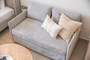 a couch with two pillows on it in a living room at Cozy Studio in Azizi Riviera Sleeps 3 with Pool in Dubai
