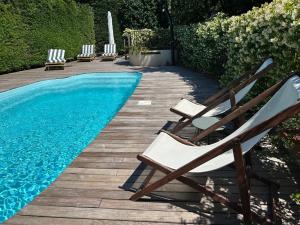 a couple of chairs sitting next to a swimming pool at Bastide le Petit Clos - les 2 Gîtes in Perpignan