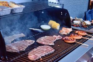 a grill with meats and corn and donuts on it at マイグレテラス in Ito