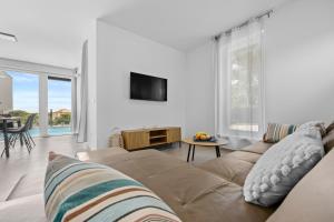 a living room with a couch and a tv at Peninsula Villas in Premantura