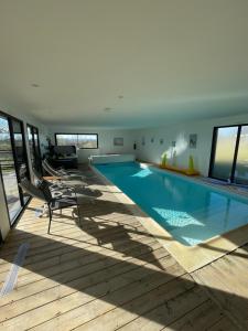 a large swimming pool in a house at Gite CARAMELLE Piscine intérieure privée chauffee toute l annee et spa St Martin in Saint-Martin-lʼHortier
