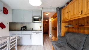 eine Küche und ein Wohnzimmer mit einem Sofa in der Unterkunft Hermine 1 N09 - 2P4 in Morillon