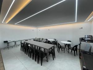 NorthamANG COMSAT Guesthouse的配有桌椅和电视的餐厅