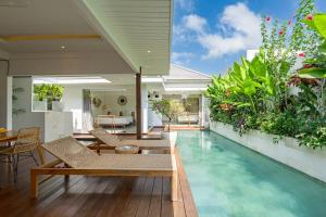- une piscine dans une maison avec des chaises et une table dans l'établissement Villa Ryky near Luna Beach Club, à Cemagi
