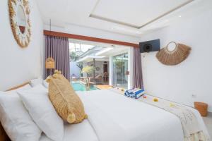 une chambre avec un grand lit blanc avec des oreillers blancs dans l'établissement Villa Ryky near Luna Beach Club, à Cemagi
