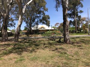 a park with trees and a house in the background at Strawbale House Bacchus Marsh in Bacchus Marsh