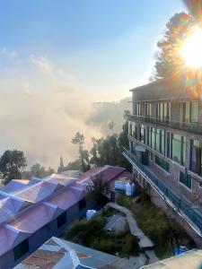 a building with the sun shining in the sky at Royal Serviced Cottages in Murree +75 photos