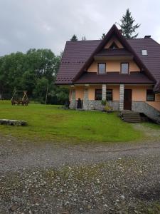 dom z brązowym dachem i trawnikiem w obiekcie Maria Chyc wynajem pokoi gościnnych w Zakopanem