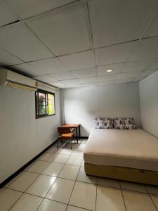 a bedroom with a bed and a table in it at เวลาสุข in Phra Nakhon Si Ayutthaya