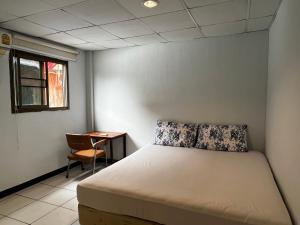 a bedroom with a bed and a desk and a window at เวลาสุข in Phra Nakhon Si Ayutthaya