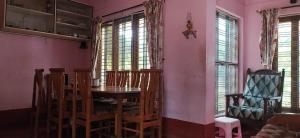 a dining room with a table and chairs and windows at Airport to Comfort Homestay Near Mangalore International Airport in Mangalore