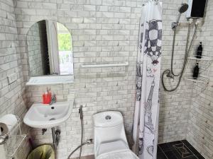 a white bathroom with a toilet and a sink at Dorothys in Pattaya South