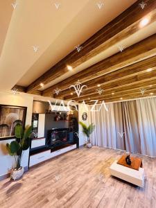 a living room with a wooden ceiling and a table at For Rent Luxurious 3-Bedroom Chalet at Hacienda Bay, North Coast, Egypt in El Alamein