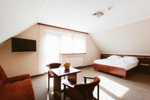 sypialnia z łóżkiem, telewizorem i kanapą w obiekcie Orange Pokoje w mieście Karpacz