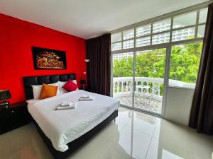 a red bedroom with a bed and a large window at Dorothys in Pattaya South