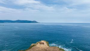a bench on a small island in the ocean at Pension O Remo in O Vicedo +39 photos