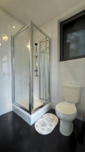 a bathroom with a toilet and a glass shower at Central Guest Studio - En-Suite - Vibrant London in London