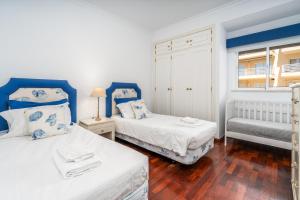 two beds in a room with blue and white at Vilamoura Central 2 Bedroom Apartment in Vilamoura +8 photos