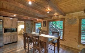 ein Esszimmer mit einem Holztisch und Stühlen in der Unterkunft Knotty Creek Retreat - Creek Access, Outdoor Firepit + Hot Tub with Creek Views! in Morganton
